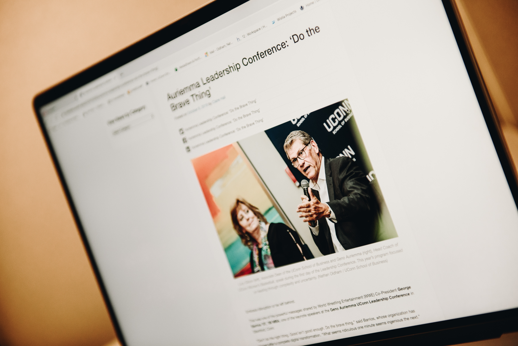 Staged photo of a laptop featuring an article titled "Auriemma Leadership Conference."