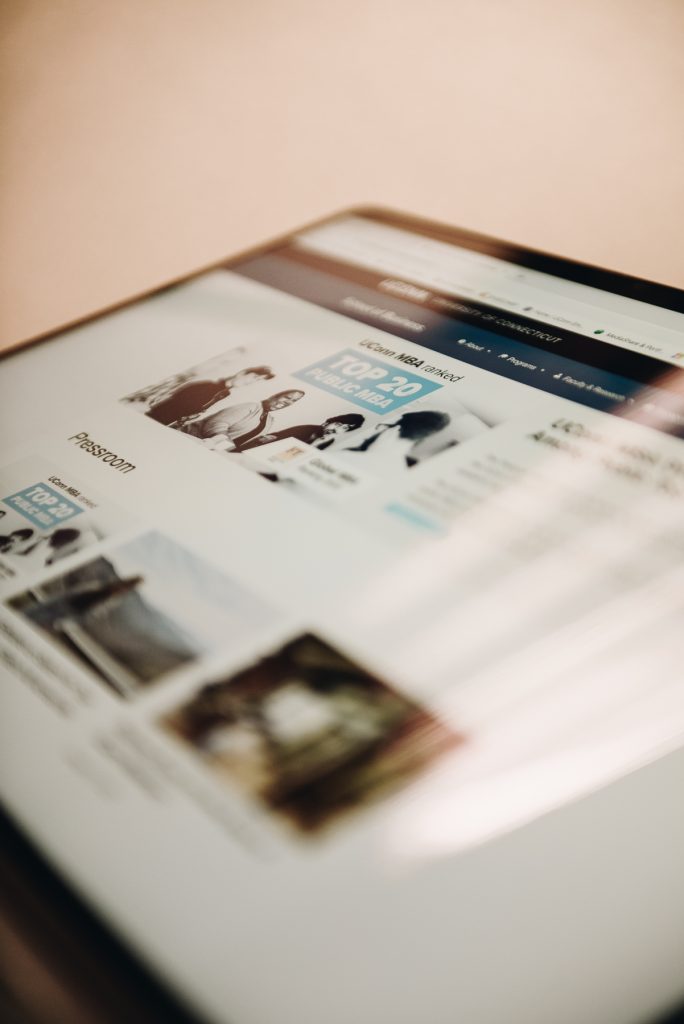Staged photo of a laptop featuring a site page on the UConn School of Business Communications website.